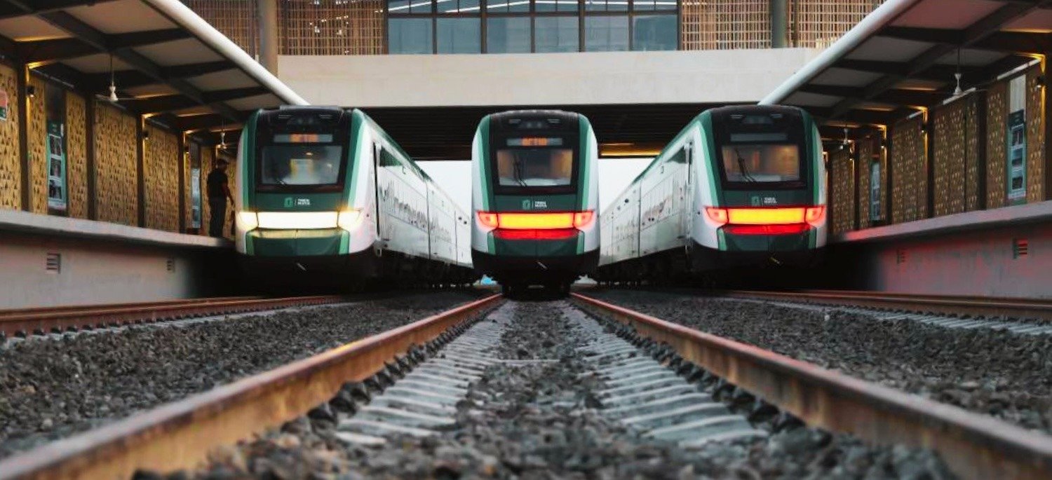 Tres vagones del Tren Maya avanzando sobre los rieles hechos con acero en México