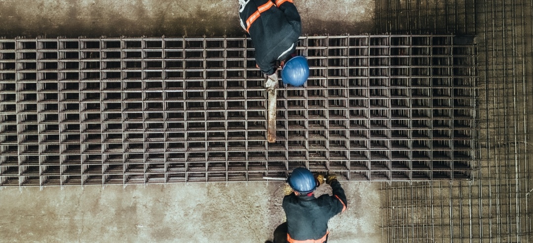 Trabajadores con casco midiendo la malla de ingeniería en un almacén de Mexlam